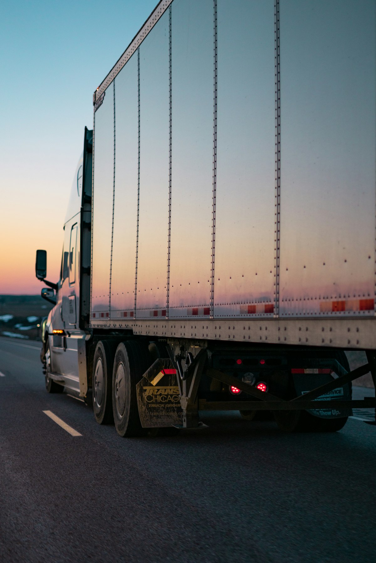 Road train truck driving through Australian outback at sunset